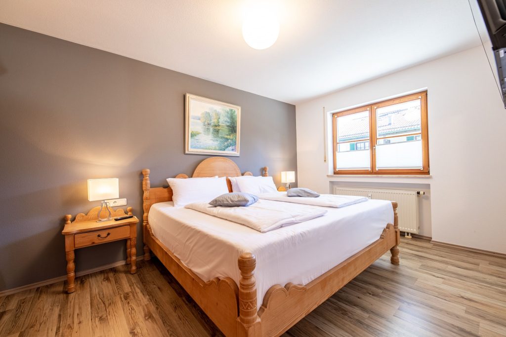 Schlafzimmer mit einem Holz Bett in Ferienwohnung in Garmisch-Partenkirchen